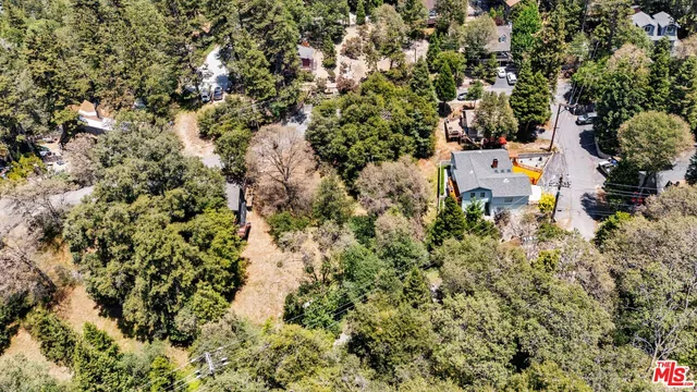 an aerial view of residential house with space and trees all around