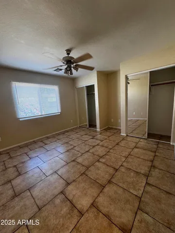 a view of a livingroom with a chandelier fan and windows