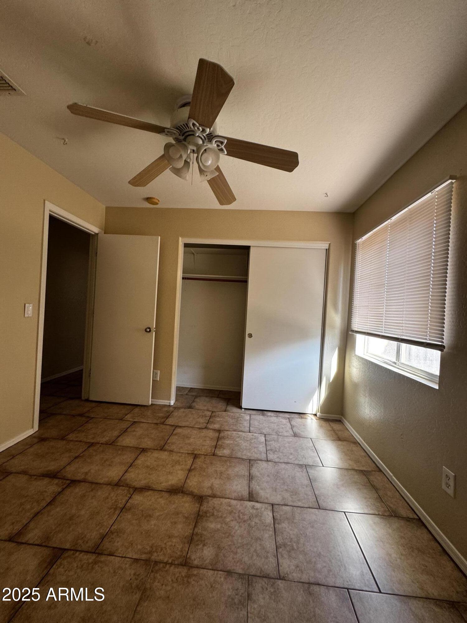 12817 North El Frio Street El Mirage, AZ 85335 - Photo 9 of 16 a view of a livingroom with a chandelier fan and windows