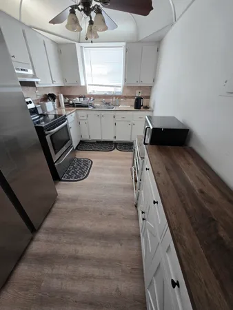 a kitchen with granite countertop a sink stove and cabinets