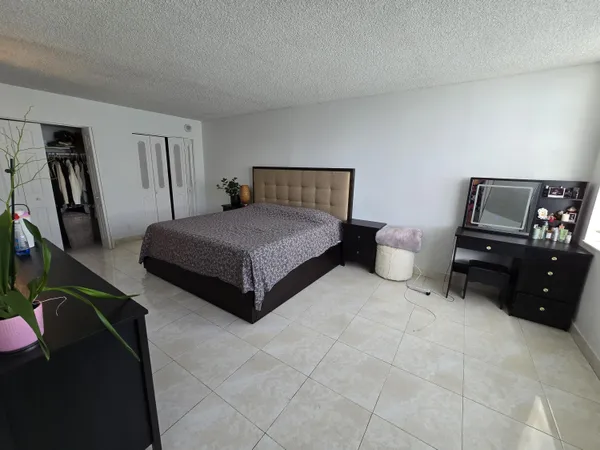 a spacious bedroom with a bed and wooden floor