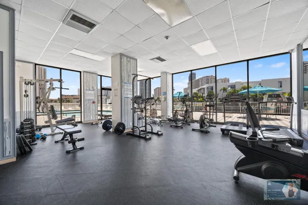 a view of a room with gym equipment and large windows