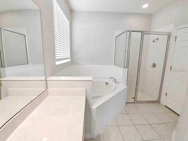 a bathroom with a bathtub a sink a vanity and a bathtub