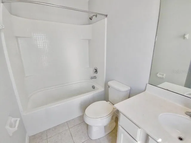 a view of an empty room with closet and a window
