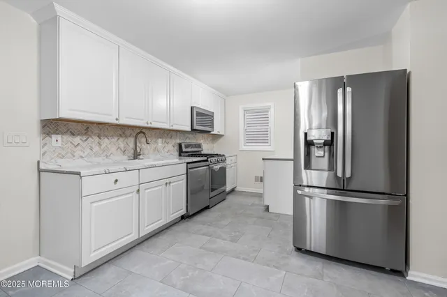 a kitchen with stainless steel appliances granite countertop a refrigerator sink and cabinets