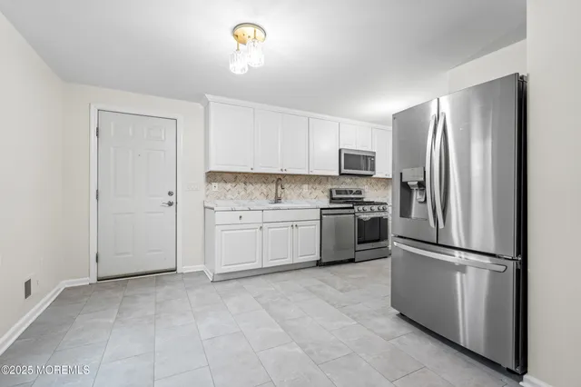 a kitchen with a refrigerator sink and cabinets