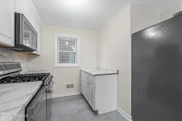 a kitchen with granite countertop a stove and a sink