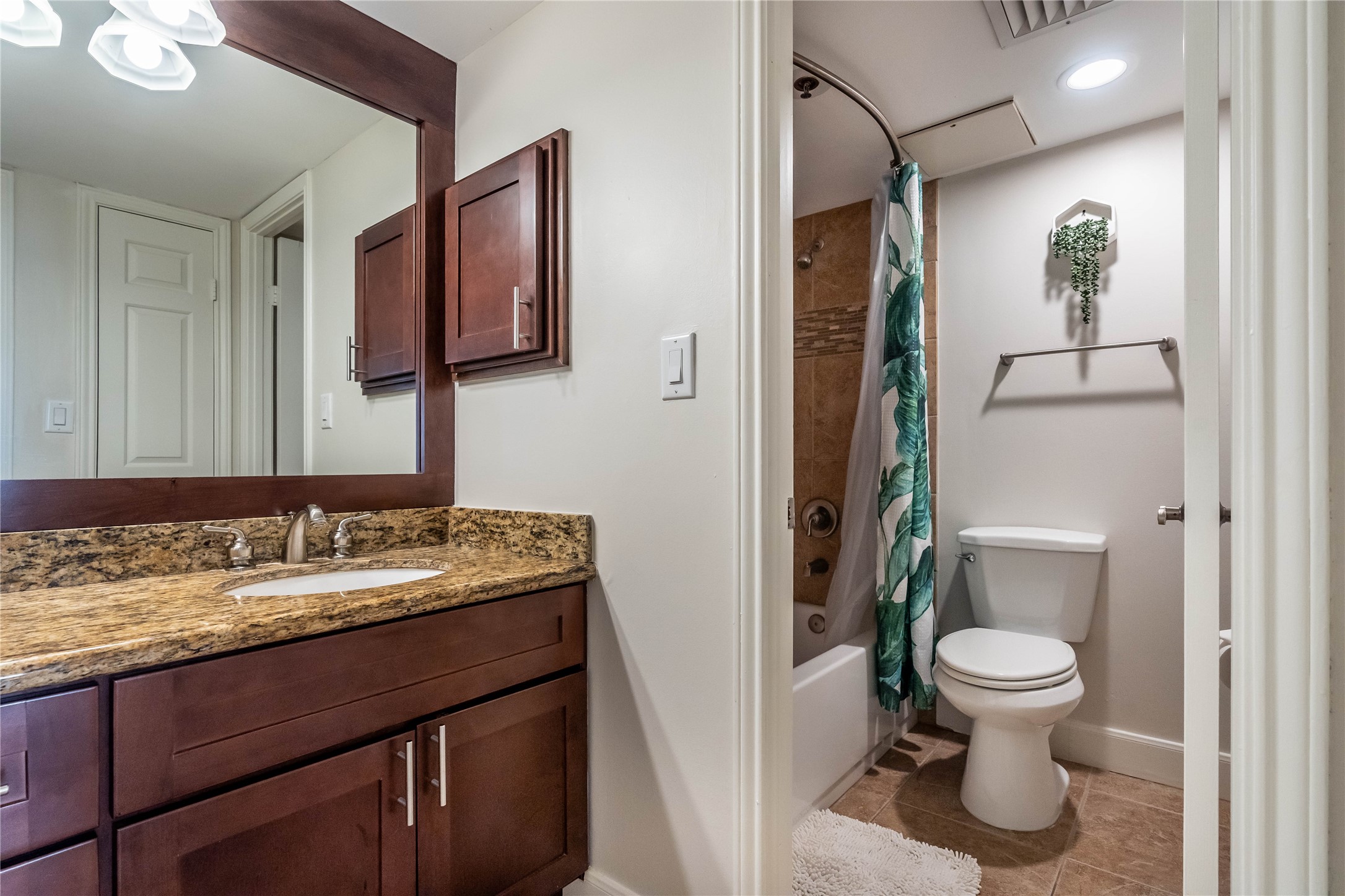 3525 Sage Road, Unit 1313 Houston, TX 77056 - Photo 13 of 18 a bathroom with a granite countertop toilet sink and mirror
