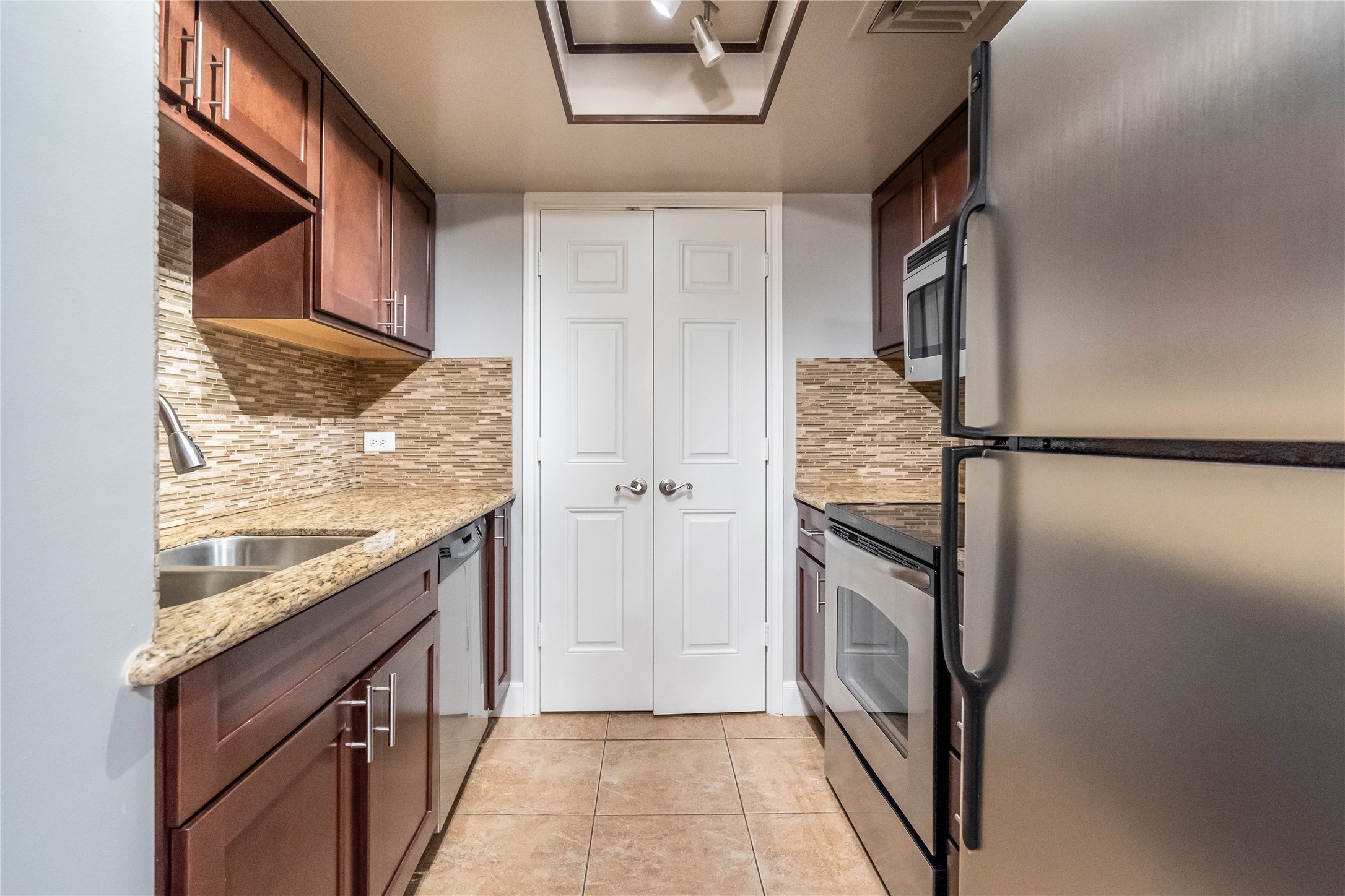 3525 Sage Road, Unit 1313 Houston, TX 77056 - Photo 4 of 18 a kitchen with granite countertop a refrigerator and a stove