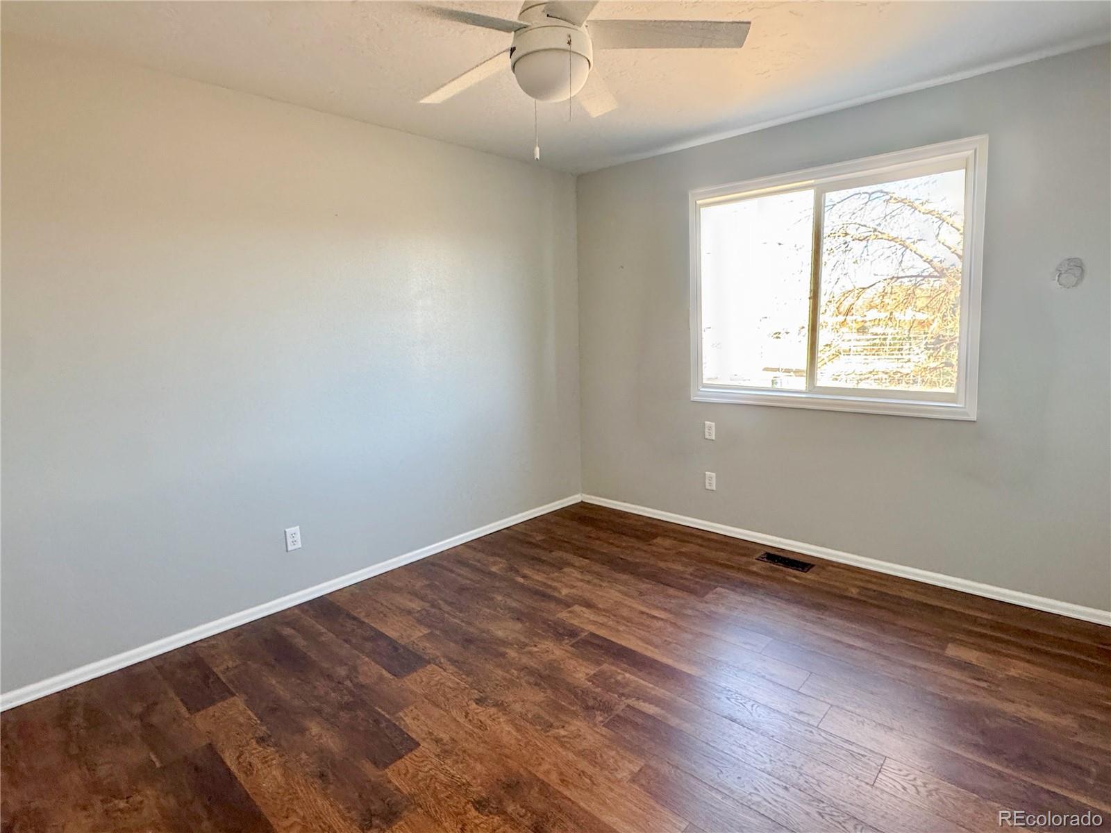 401 Rider Road Rangely, CO 81648 - Photo 15 of 23 an empty room with a window and wooden floor