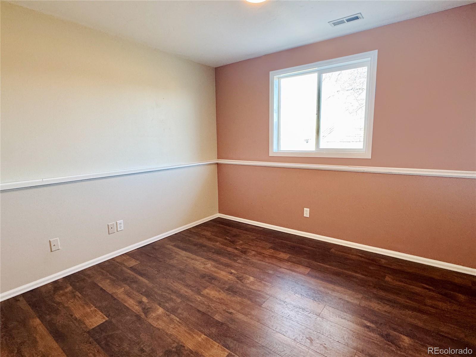 401 Rider Road Rangely, CO 81648 - Photo 19 of 23 an empty room with wooden floor and windows