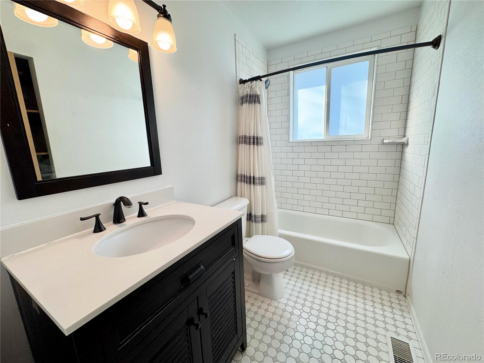 401 Rider Road Rangely, CO 81648 - Photo 20 of 23 a bathroom with a sink a toilet a mirror and shower