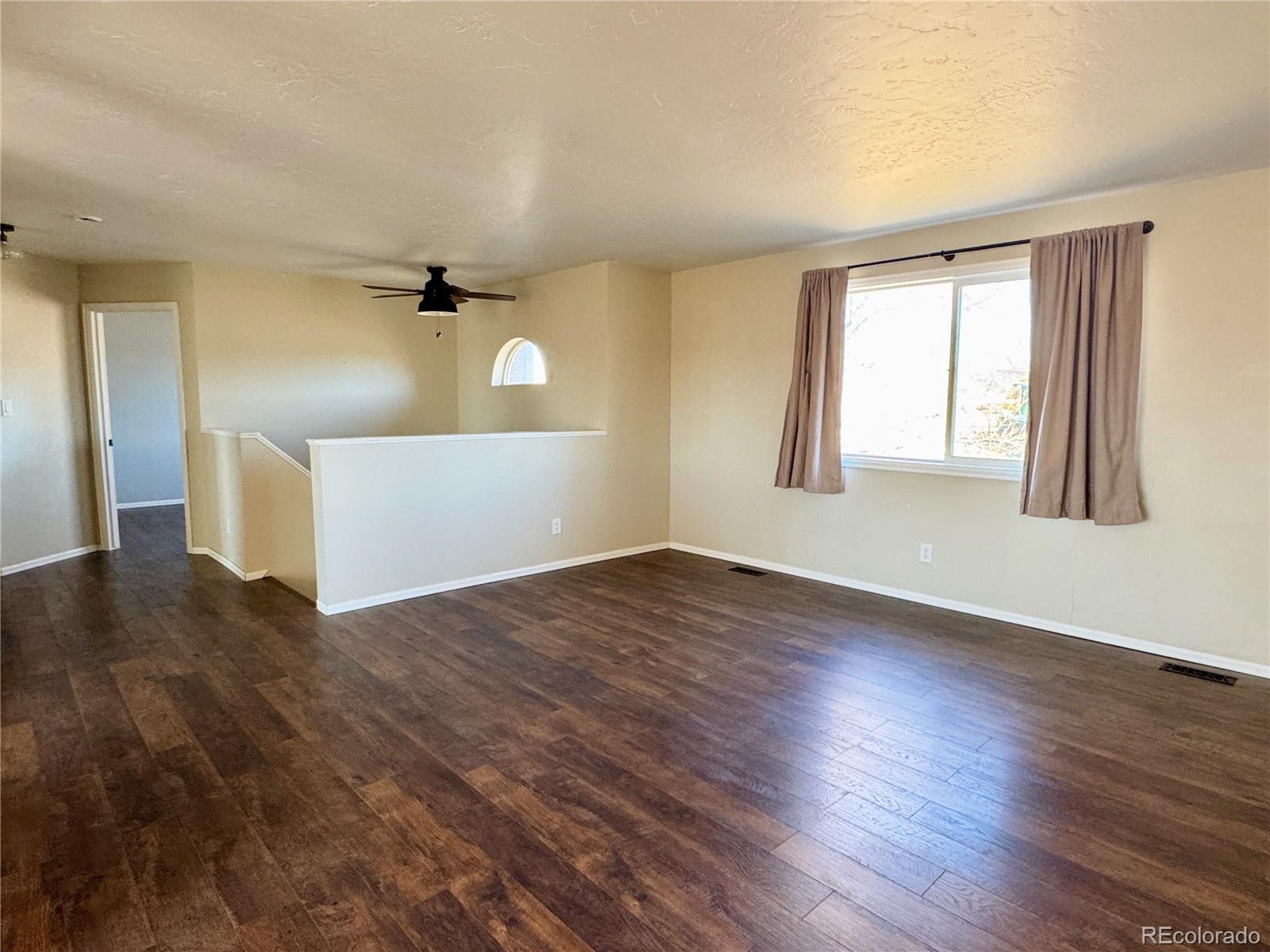 401 Rider Road Rangely, CO 81648 - Photo 10 of 23 a view of empty room with wooden floor and fan