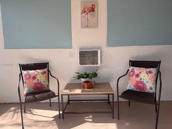 a view of a chair and table in backyard of the house