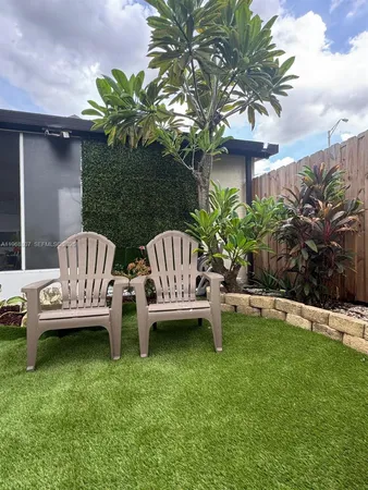 a view of a backyard with plants and wooden fence