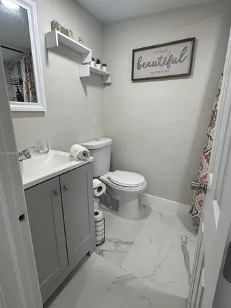 a bathroom with a toilet sink and mirror