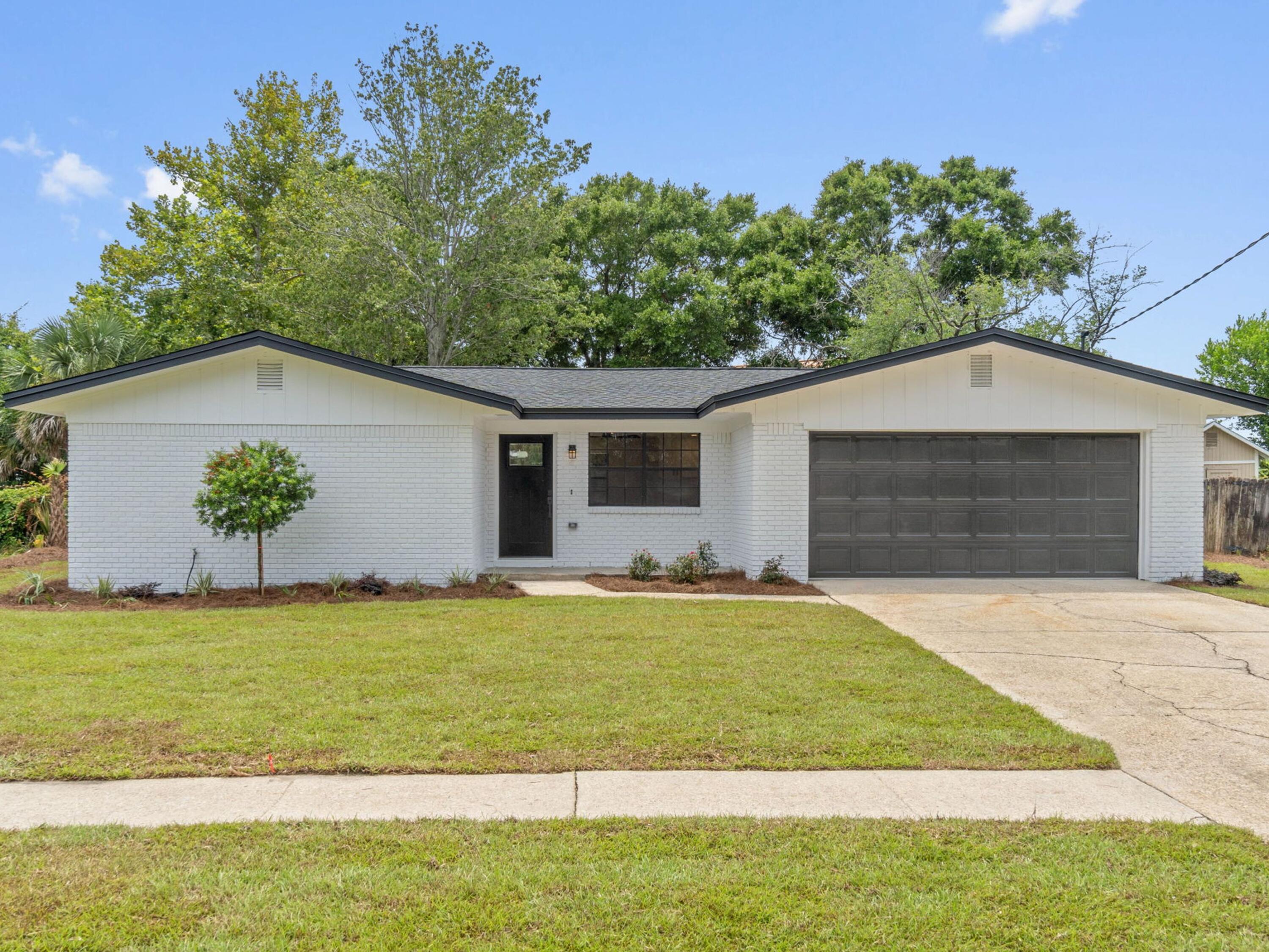 609 Sea View Circle Destin, FL 32541 - Photo 1 of 45 a front view of a house with a yard and garage