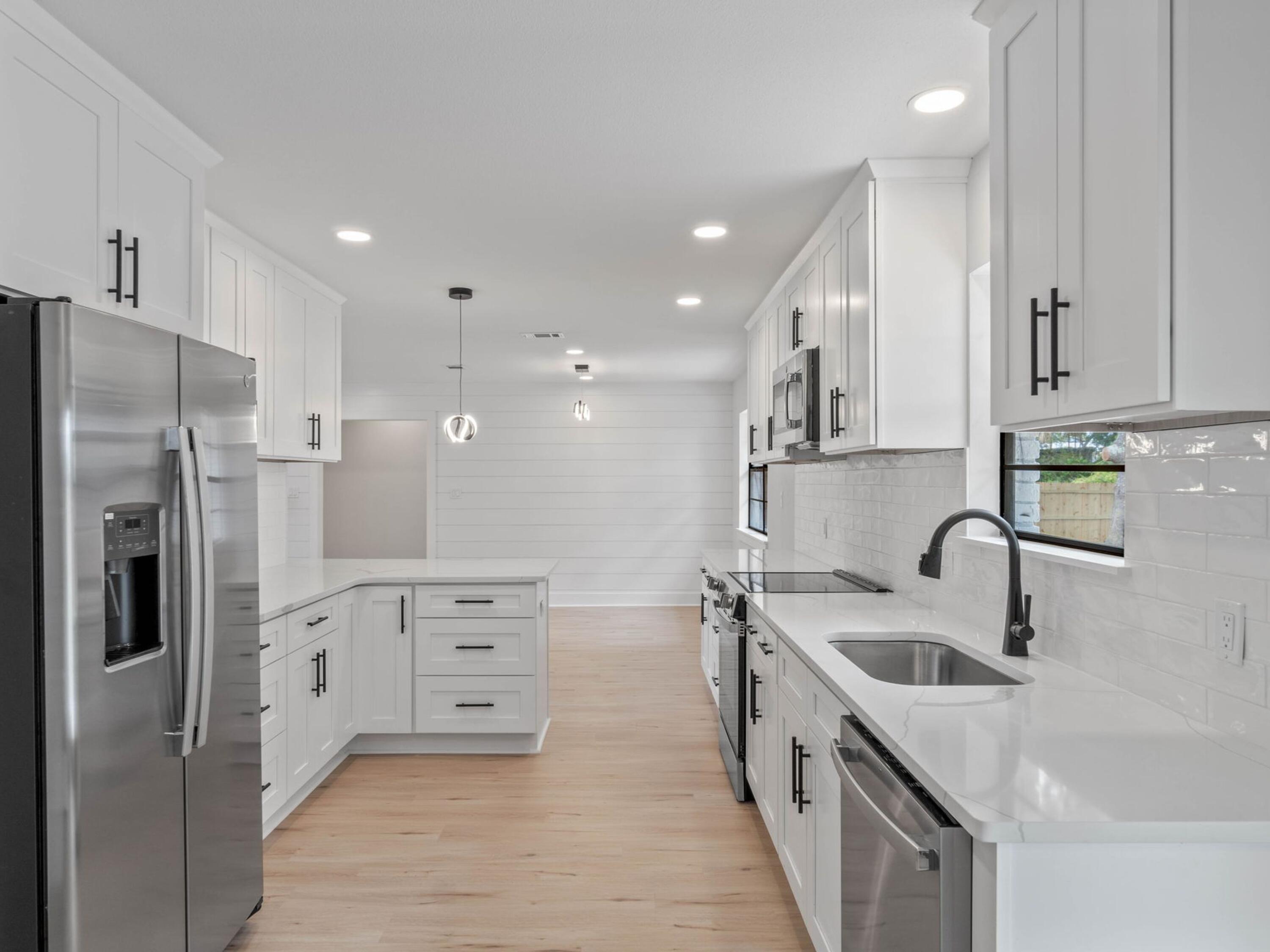 609 Sea View Circle Destin, FL 32541 - Photo 16 of 45 a kitchen with a refrigerator sink and cabinets