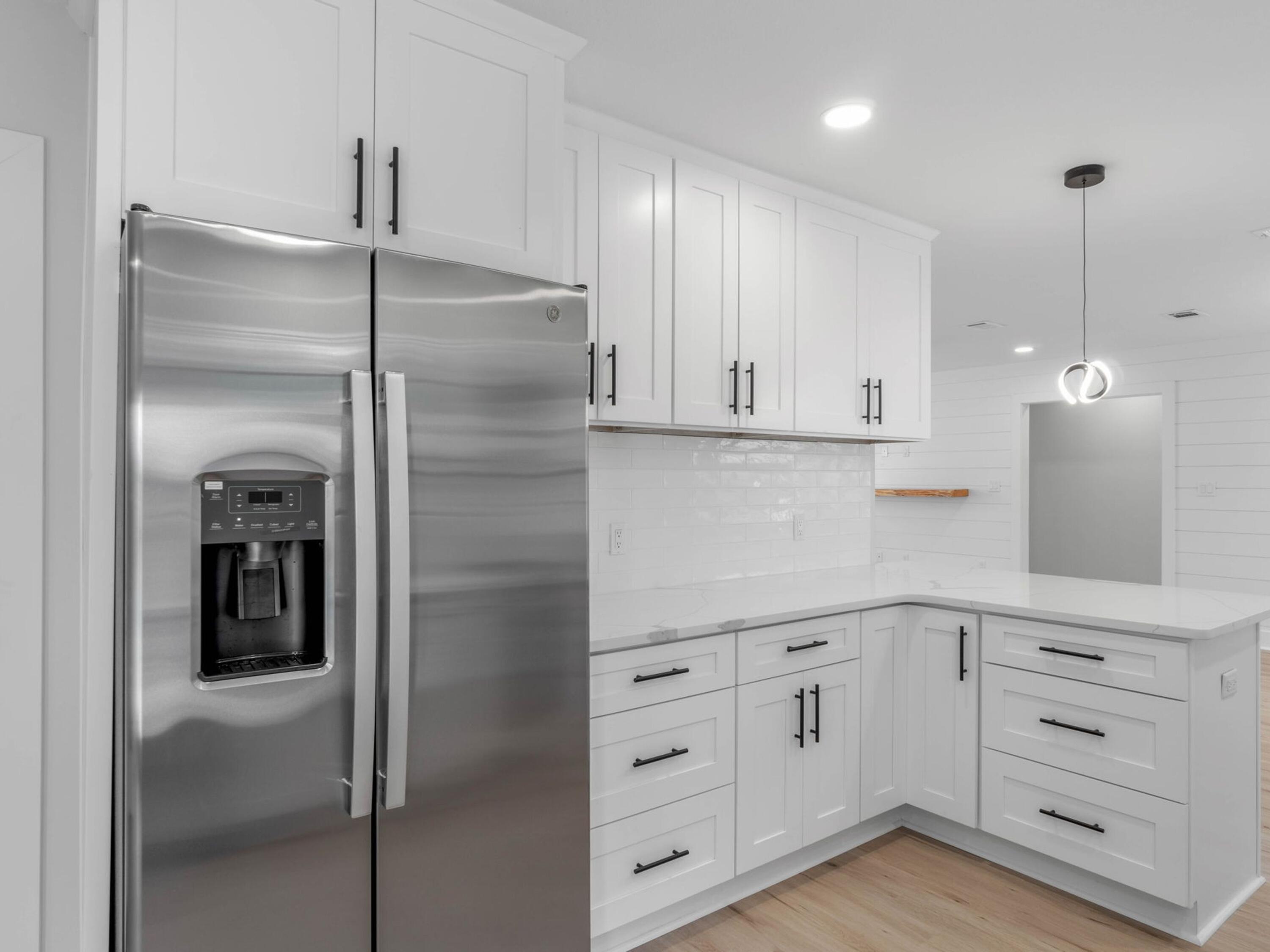 609 Sea View Circle Destin, FL 32541 - Photo 17 of 45 a kitchen with white cabinets and refrigerator