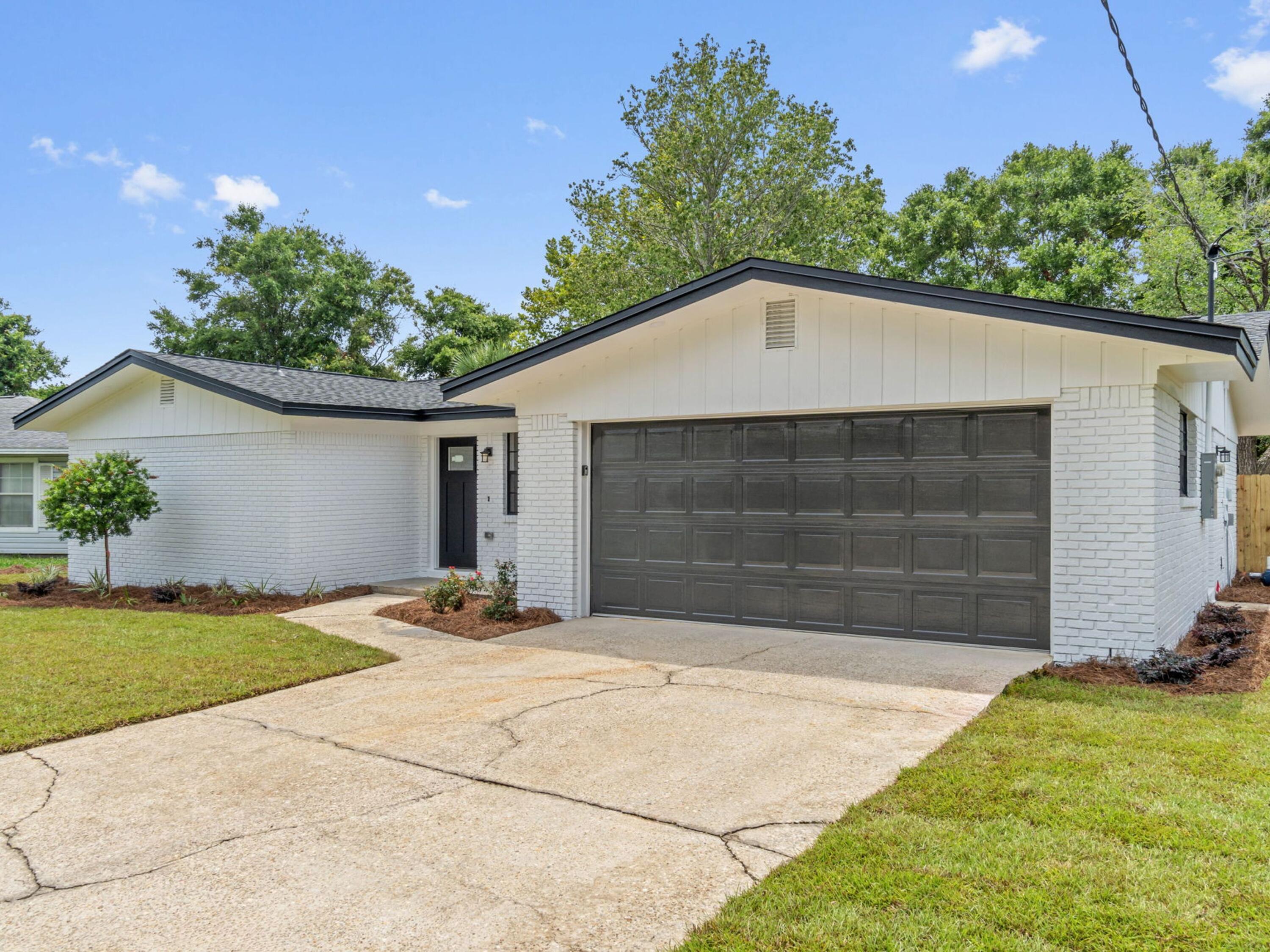 609 Sea View Circle Destin, FL 32541 - Photo 2 of 45 a front view of a house with a yard and garage