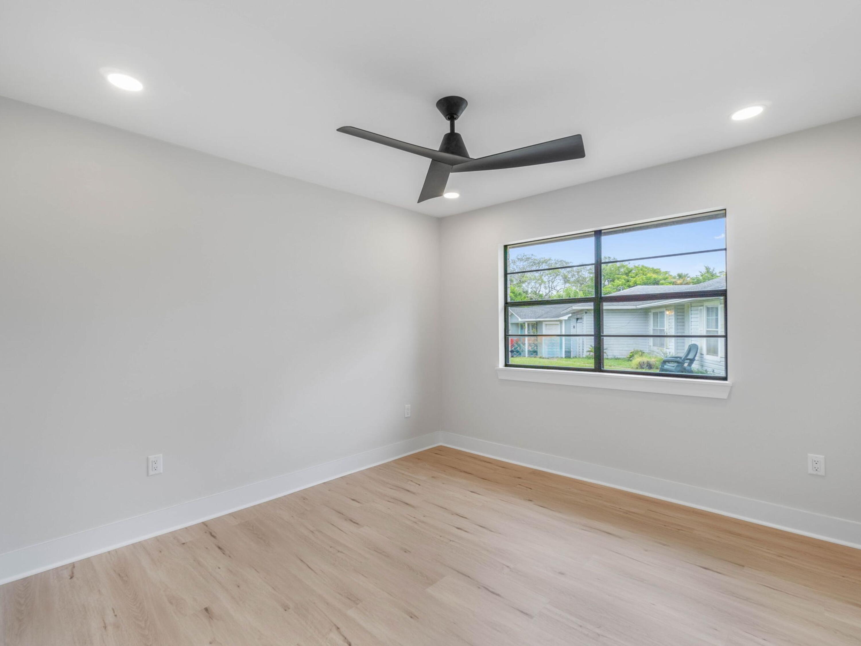 609 Sea View Circle Destin, FL 32541 - Photo 23 of 45 an empty room with wooden floor ceiling fan and windows