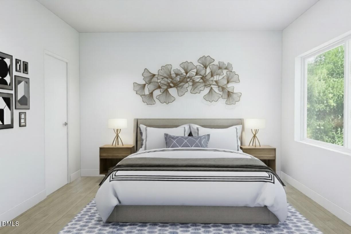 709 East Lenoir Street, Unit 201 Raleigh, NC 27601 - Photo 6 of 13 a bed sitting in a bedroom next to a window