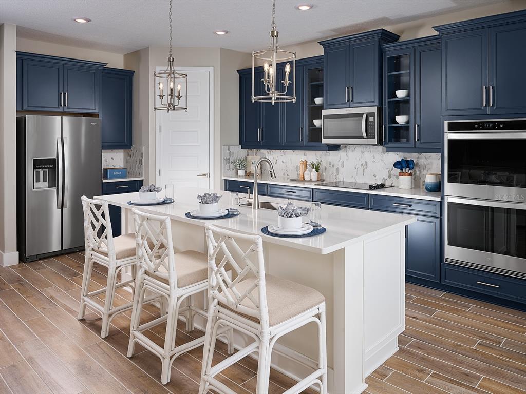 1004 British Circle Daytona Beach, FL 32124 - Photo 2 of 8 a kitchen with stainless steel appliances kitchen island granite countertop a sink and cabinets