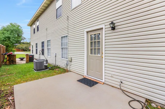 a view of a white house with a yard and a table and chairs