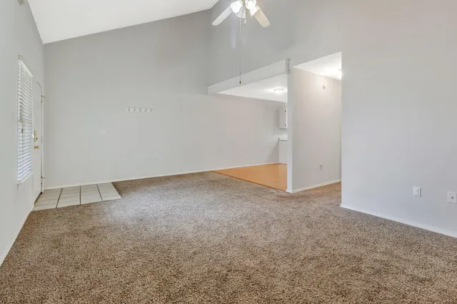 an empty room with a ceiling fan and entryway