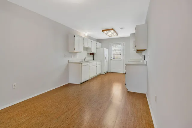 a view of a kitchen with wooden floor and electronic appliances