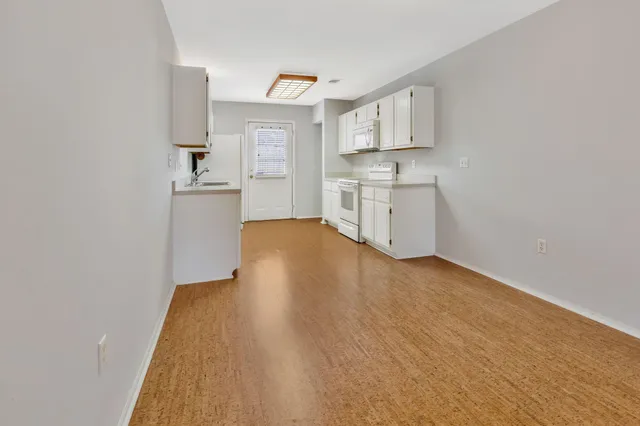 a kitchen with stainless steel appliances granite countertop a sink and cabinets with wooden floor