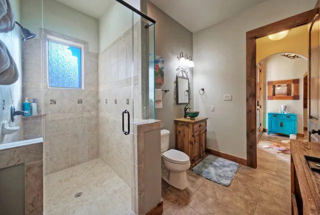 a bathroom with a sink a toilet and shower