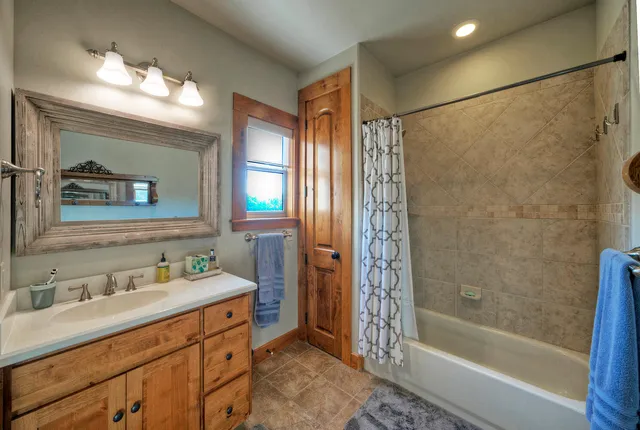 a bathroom with a double vanity sink mirror and shower