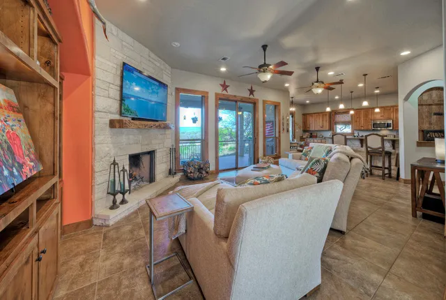 a living room with furniture a fireplace and chandelier
