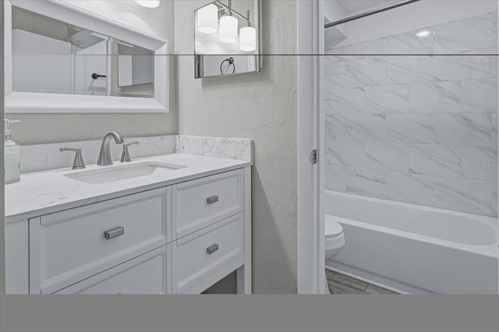 2508 Southwest 35th Place, Unit D19 Gainesville, FL 32608 - Photo 11 of 25 a bathroom with a granite countertop sink mirror vanity and toilet