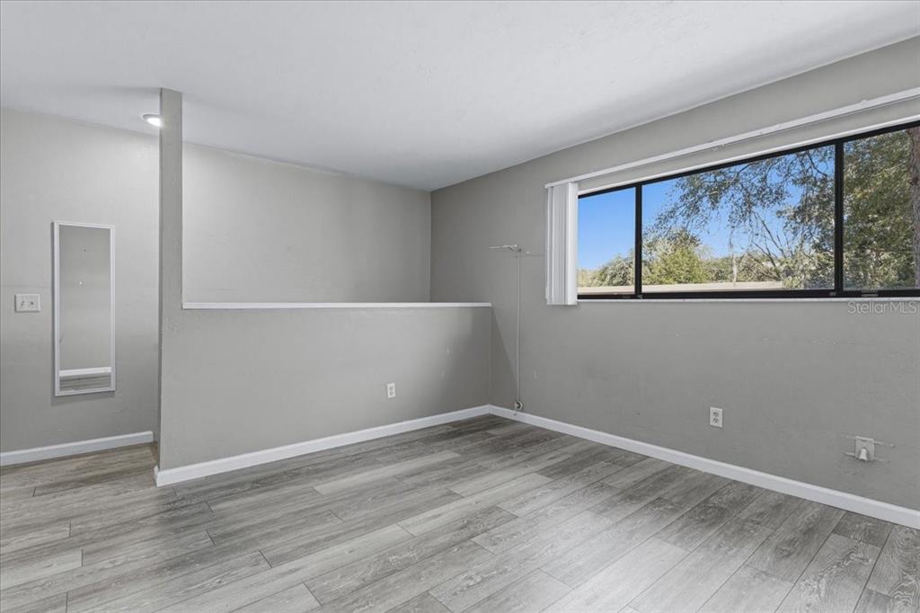 2508 Southwest 35th Place, Unit D19 Gainesville, FL 32608 - Photo 20 of 25 a view of an empty room with wooden floor and painting on the wall