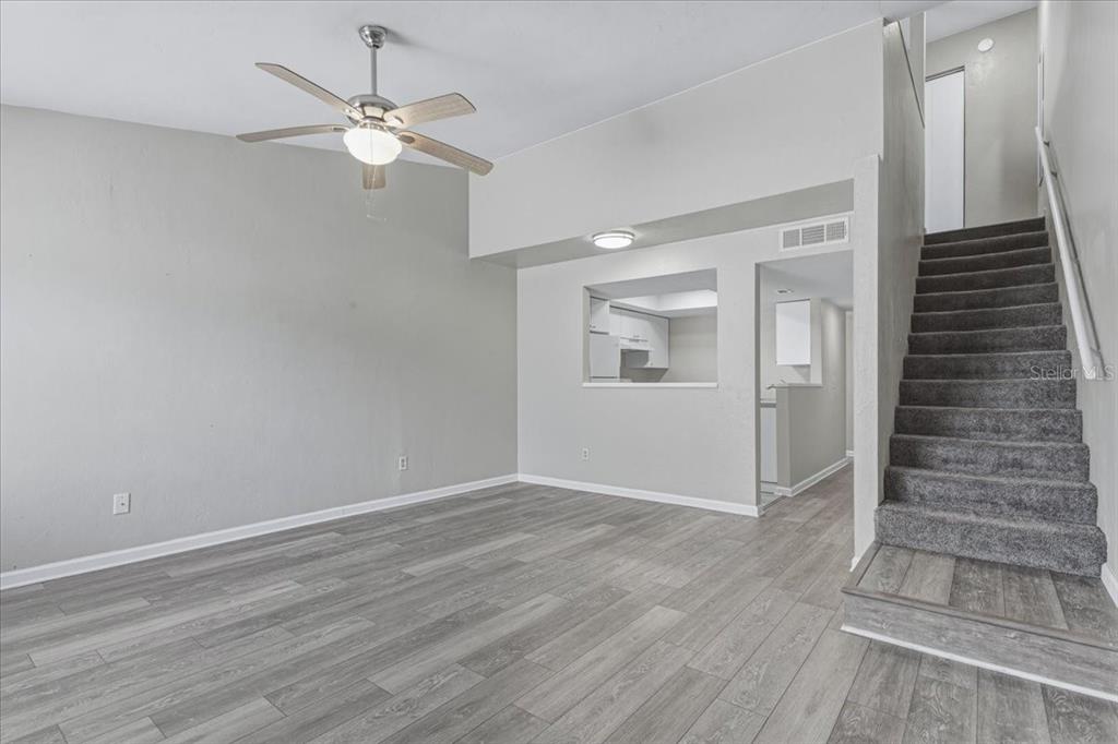 2508 Southwest 35th Place, Unit D19 Gainesville, FL 32608 - Photo 4 of 25 an empty room with wooden floor fan and windows