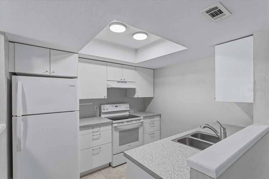 2508 Southwest 35th Place, Unit D19 Gainesville, FL 32608 - Photo 7 of 25 a kitchen with white cabinets and white appliances