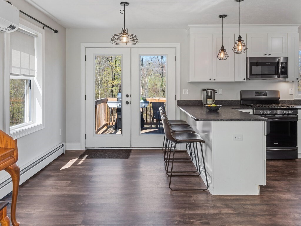 56 Carter Road Westminster, MA 01473 - Photo 7 of 36 a kitchen with stainless steel appliances granite countertop a stove top oven a refrigerator a sink and a dining table with wooden floor