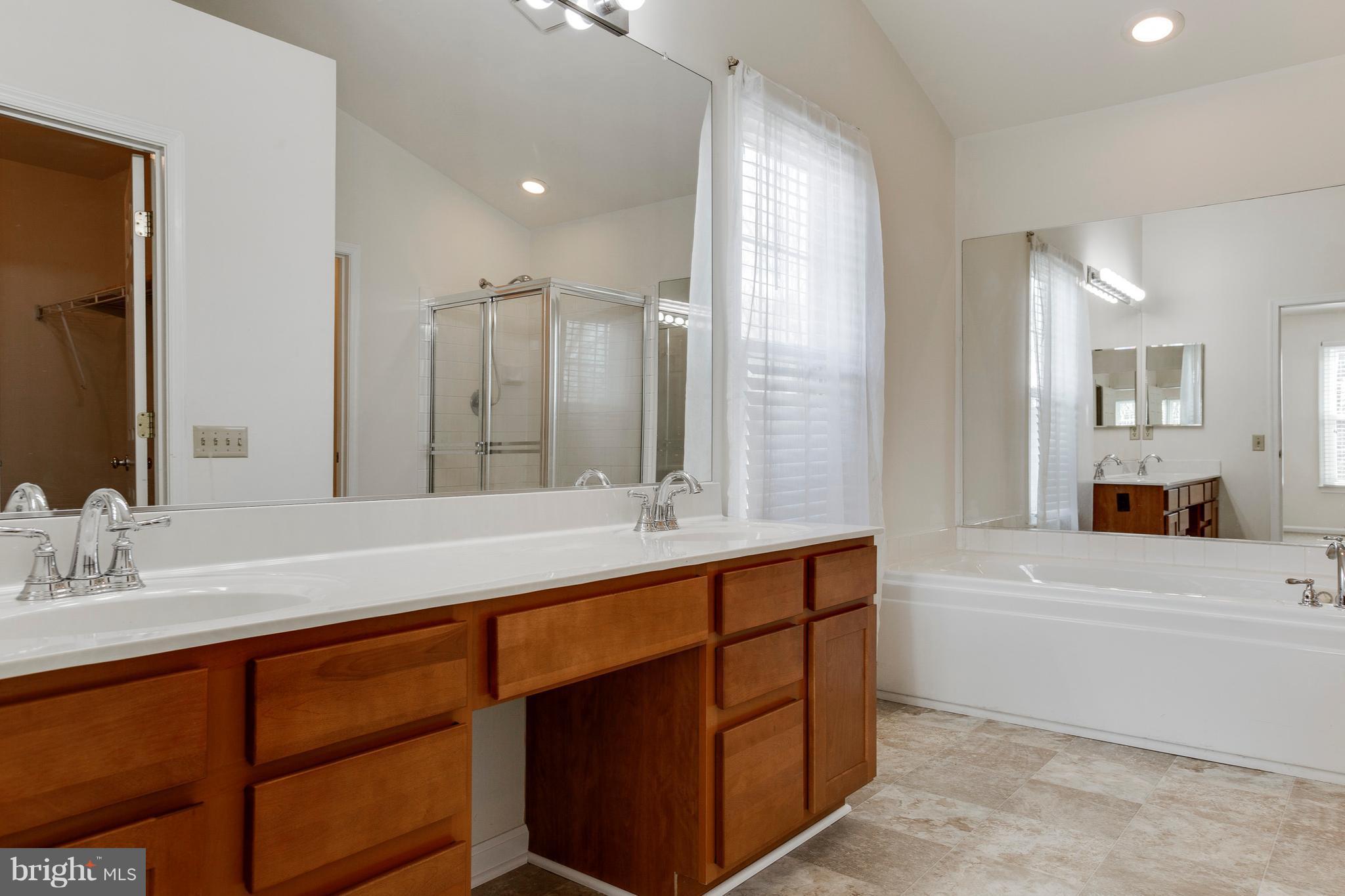 8402 Shadeland Road Laurel, MD 20724 - Photo 19 of 30 a bathroom with a sink double vanity granite tub shower and a mirror