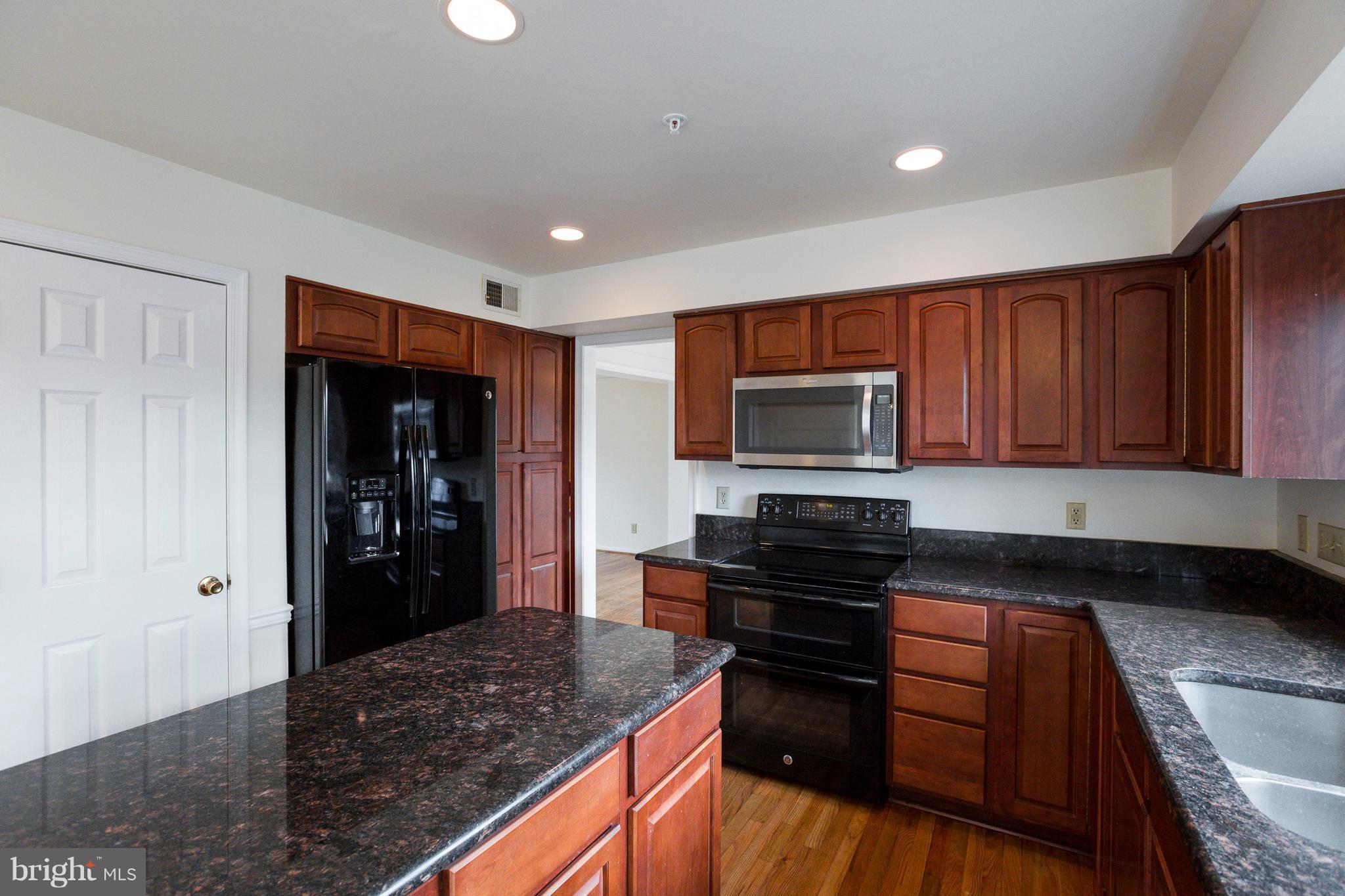 8402 Shadeland Road Laurel, MD 20724 - Photo 6 of 30 a kitchen with granite countertop stainless steel appliances and wooden cabinets