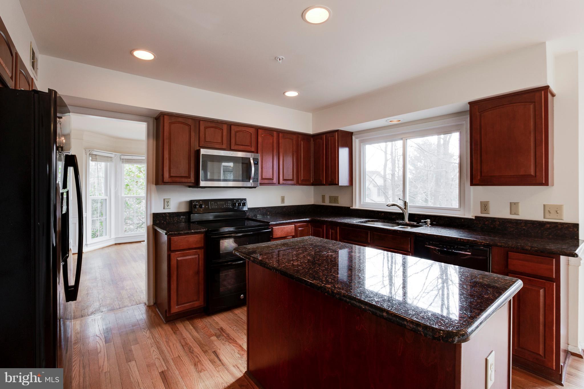 8402 Shadeland Road Laurel, MD 20724 - Photo 8 of 30 a kitchen with granite countertop stainless steel appliances and wooden cabinets