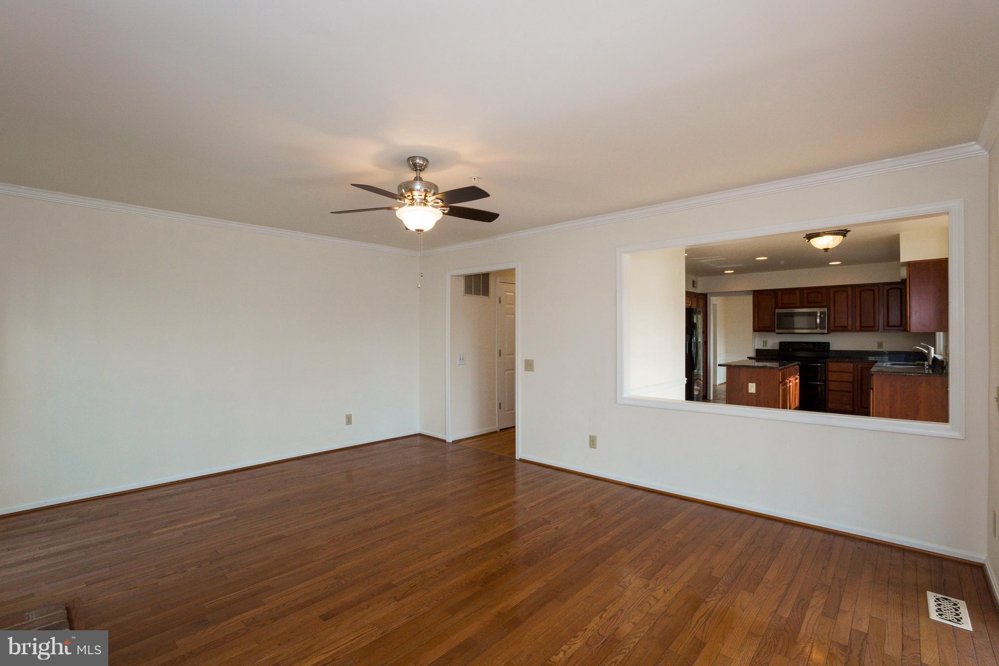 8402 Shadeland Road Laurel, MD 20724 - Photo 9 of 30 an empty room with wooden floor and kitchen view