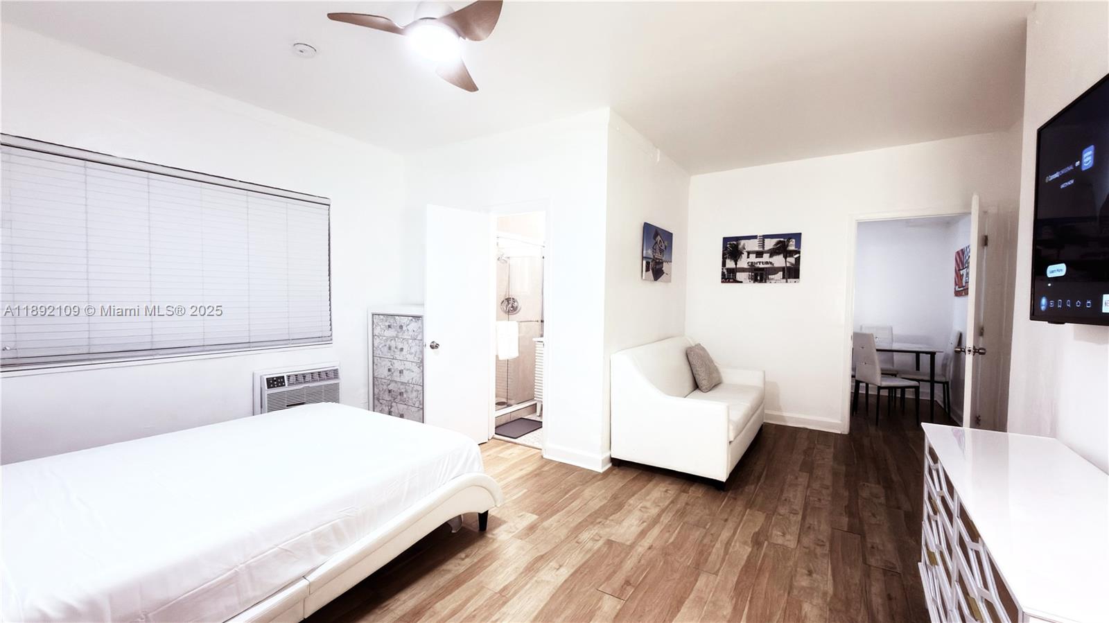 a spacious bedroom with a bed and a flat screen tv