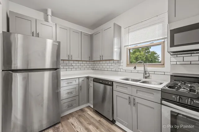 a kitchen with appliances a sink and cabinets