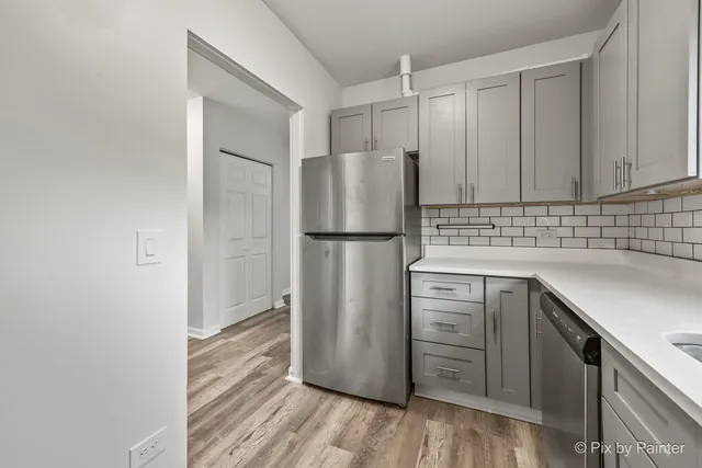 a kitchen with a refrigerator sink and cabinets