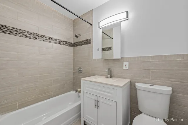 a bathroom with a sink toilet vanity and shower