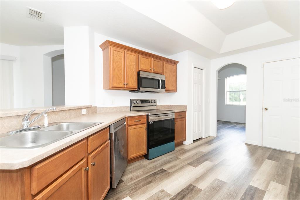 3858 Southwest 161st Street Ocala, FL 34473 - Photo 50 of 67 a kitchen with granite countertop a sink cabinets and stainless steel appliances