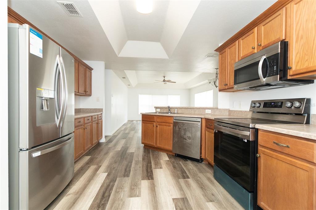 3858 Southwest 161st Street Ocala, FL 34473 - Photo 54 of 67 a kitchen with stainless steel appliances granite countertop a refrigerator a stove top oven a sink and dishwasher