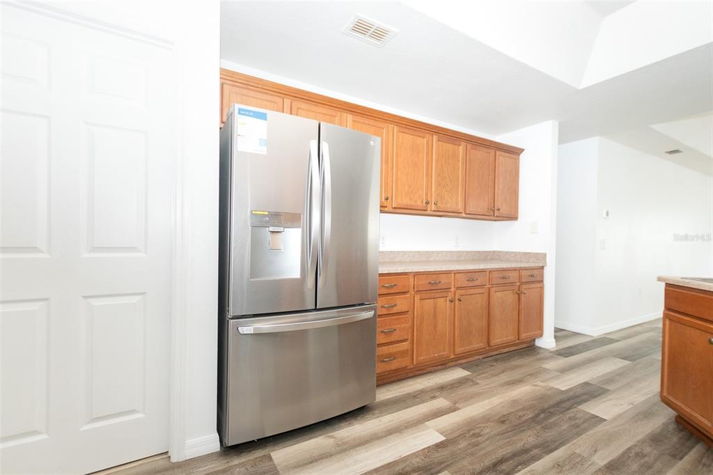 3858 Southwest 161st Street Ocala, FL 34473 - Photo 55 of 67 a kitchen with cabinets stainless steel appliances and wooden floor